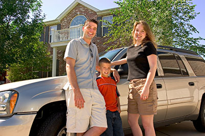 a man and a woman standing in front of a car